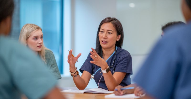 Ärztin im Austausch mit dem Team · Arzt Coaching